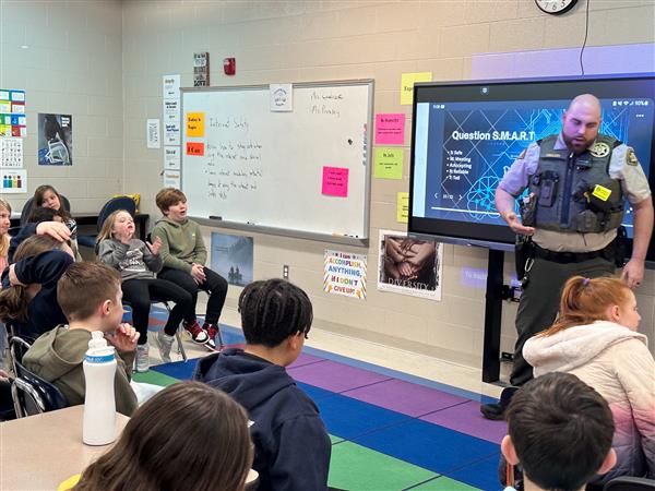police officer talking to class of students